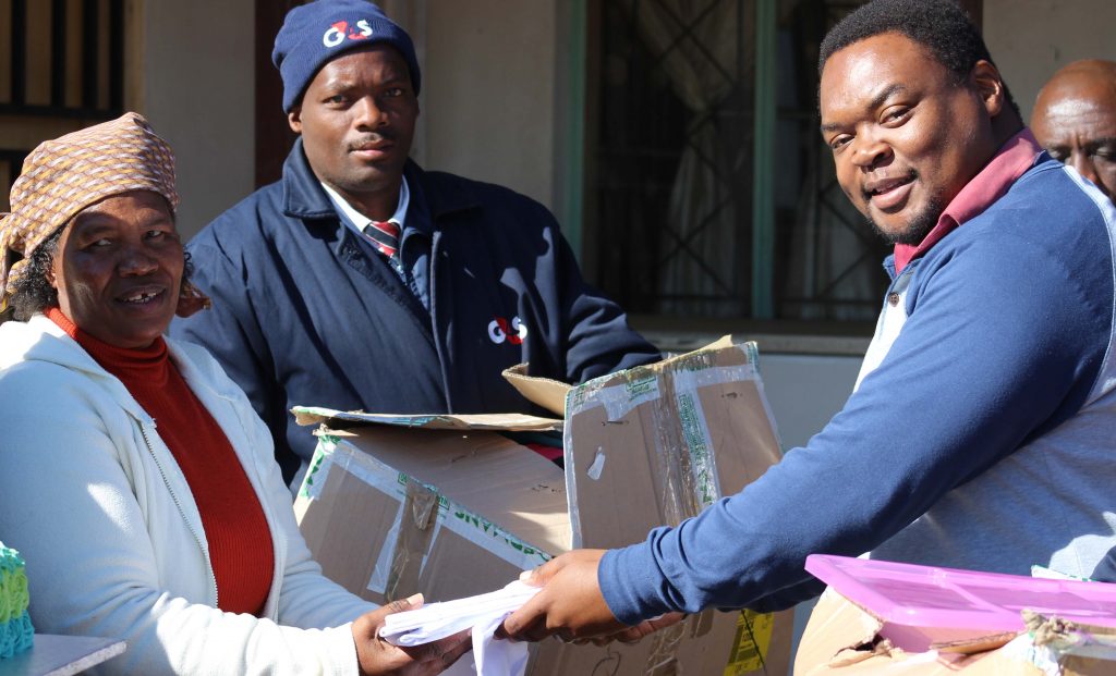 Ministry of Hope founder Mamonyane Mohale recieves goodies from Maseru Mall Centre Manager Baholo Chimombe and G4S employees who had accompanied him 