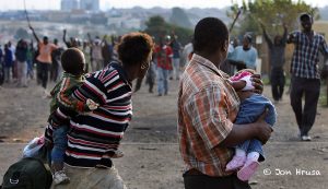 A family flees ongoing xenophobic attacks in Ramaphosa squatter camp east of Johannesburg, South Africa, 18 May 2008. South Africans of Zulu and Xhosa ethnicity attacked Mozambicans and Zimbabweans in xenophobic attacks that have spread across the country's economic heartland of Gauteng province, leaving thousands of foreigners destitute.