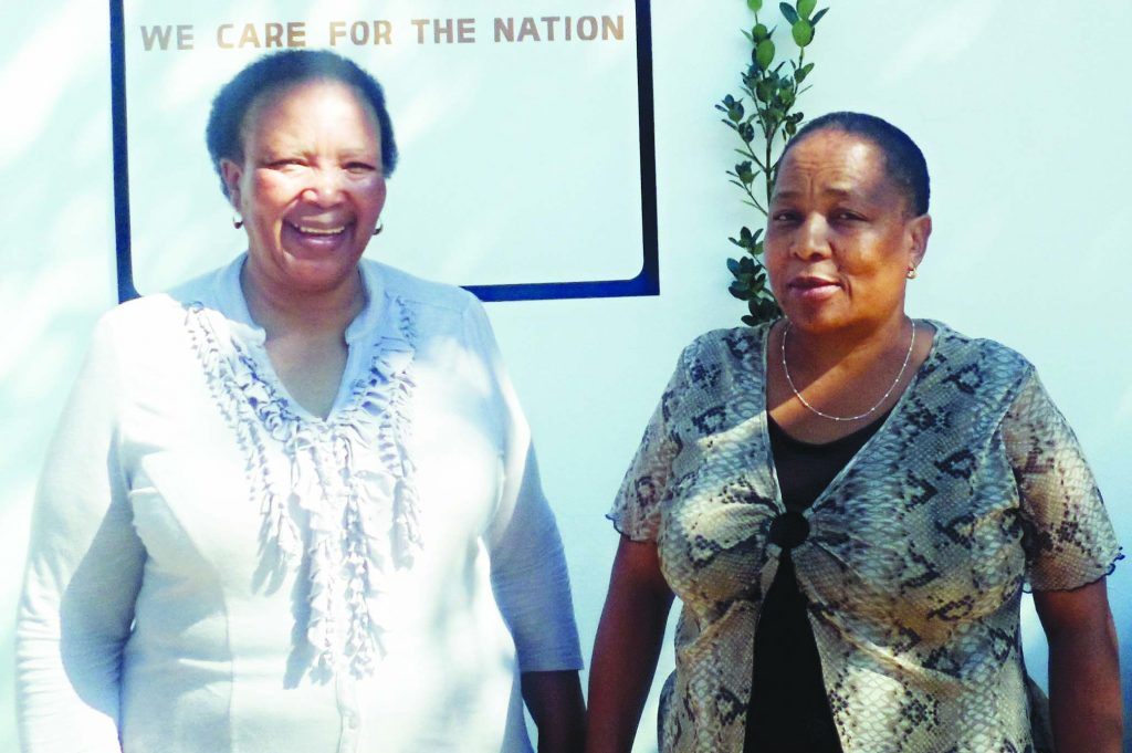 Care for Basotho National Coordinator Mathasi Kurubally  (left) stands with President Malintle Matlakeng outside the new Care for Basotho premises 1