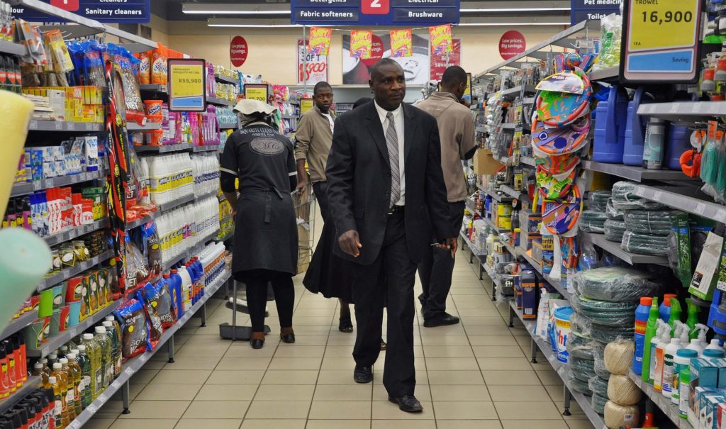 Zambians walk past a Shoprite store in the capital Lusaka.