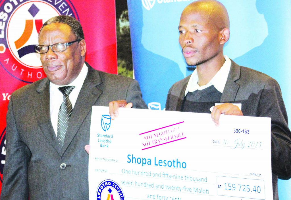 Lebohang Handy receives a cheque from Minister of Small Business Cooperatives and Marketing Thabiso Litsiba during the Bacha Entrepreneurship Project awards in July 