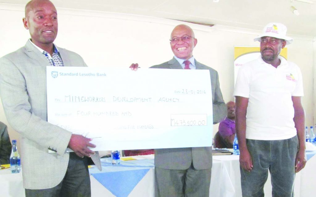 Harmony's Lebohang Shabe (left) hands over the cheque to BAHOFA represenattives