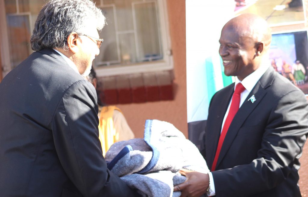 One of the donors, Dr Peerbhai hands over one of the 500 blankets to Minister of Foreign Affairs and Interantional Relations Tlohang Sekhamane