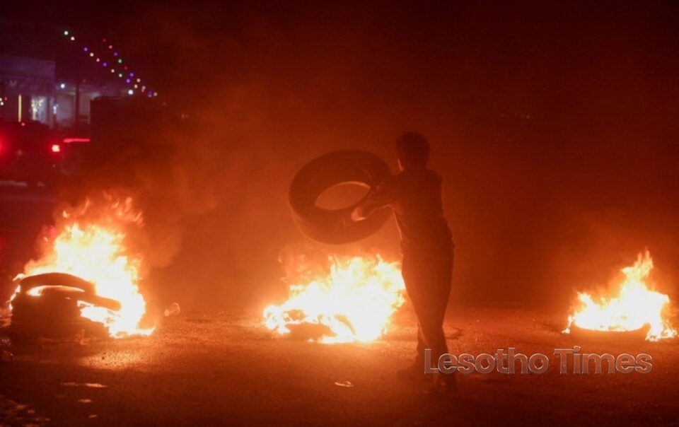 Protester in Aleppo burns tyres during demonstrations over fuel price increases in Syria